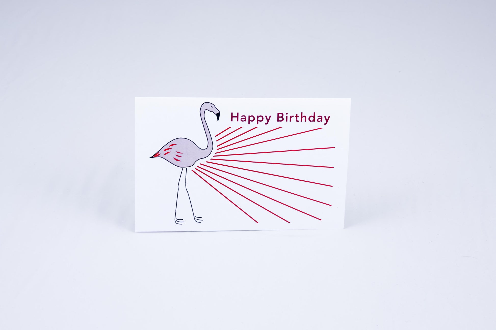 A birthday cake with 4 lit candles & greeting on top