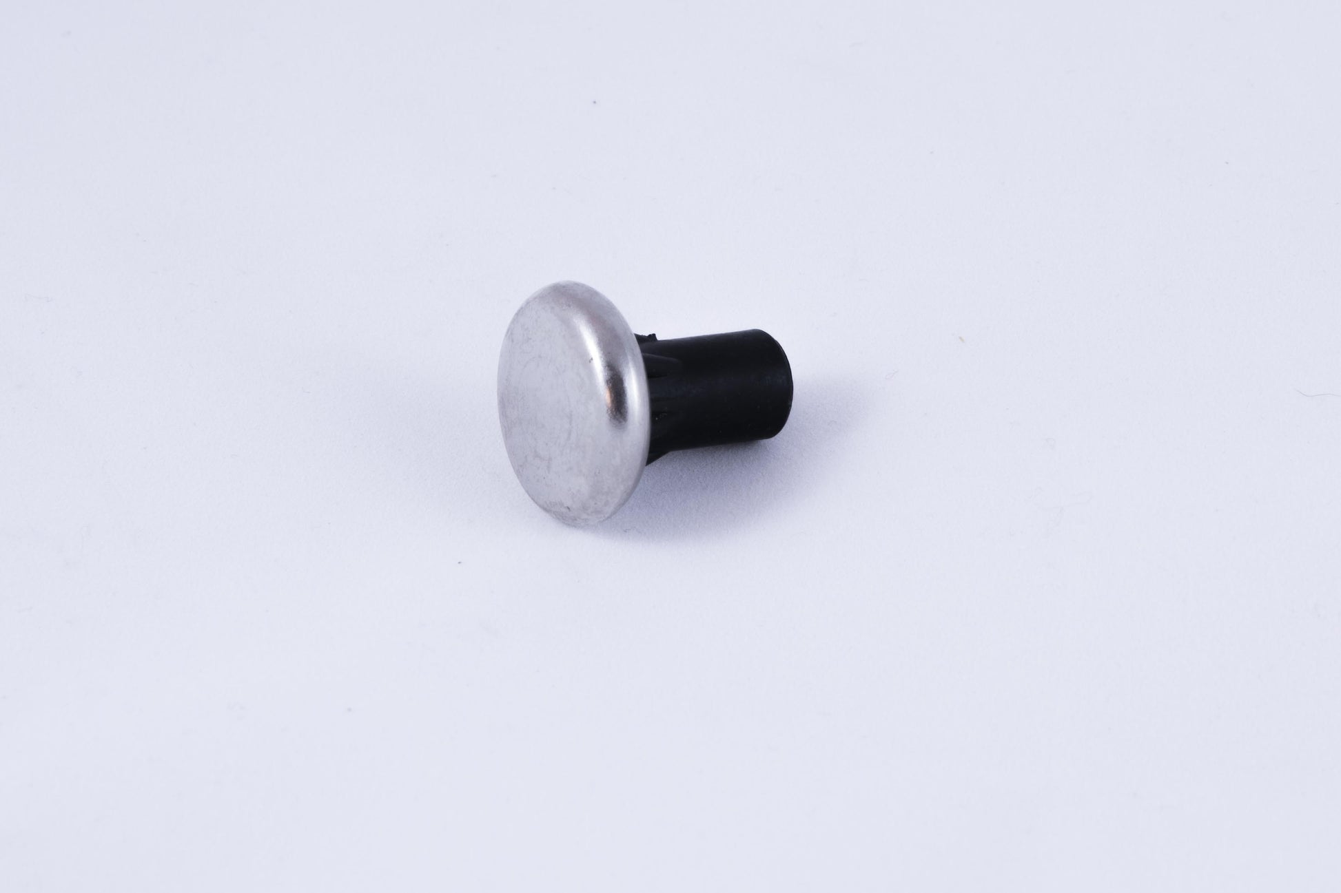 Circular metal cane tip with black rubber fixture.