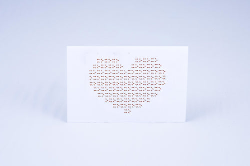 Card displaying a heart made out of Braille X's and O's