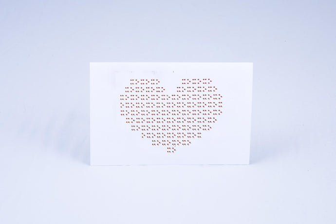 Card displaying a heart made out of Braille X's and O's