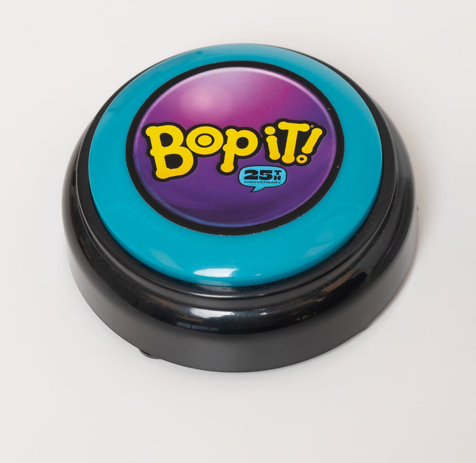 Bop It Button in classic '90s colors (teal, purple, and black)