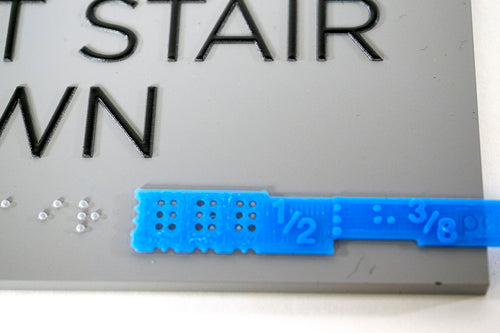 Sign template testing Braille on a Stair exit sign.